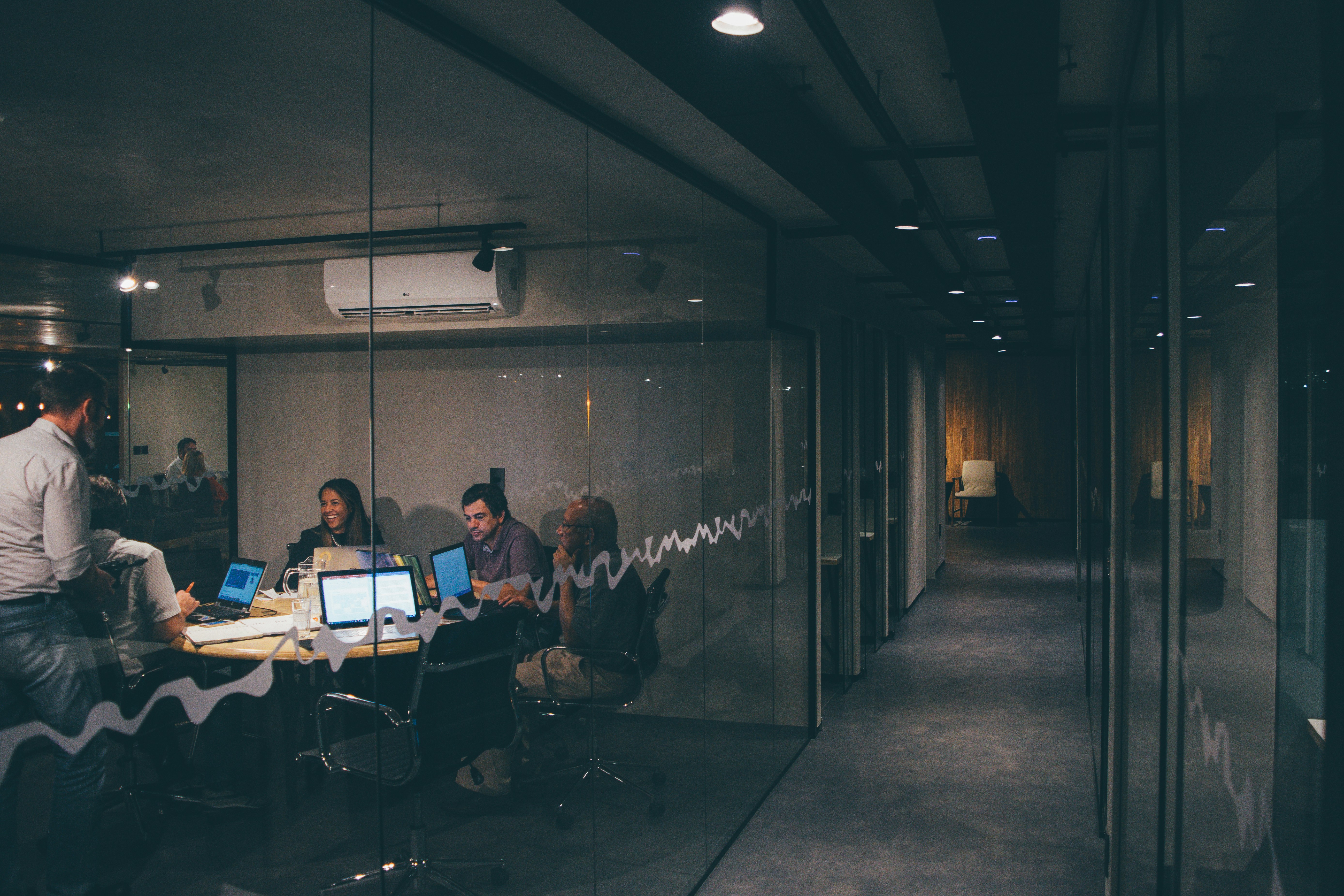 Candidates meeting in an interview, seen through a glass office wall